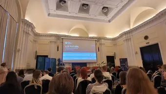 Conference room is full of people. There is presentation visible.
