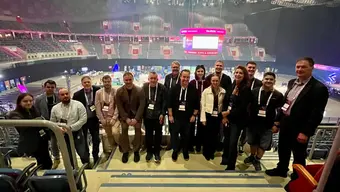 Group of people in Tauron Arena. They are standing. Expo in background.