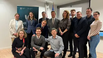 Group of 13 people posing for photo