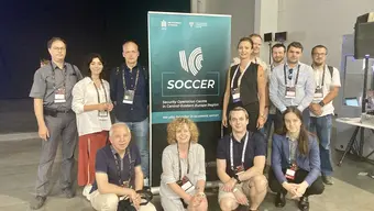 Group of people with SOCCER banner behind them.