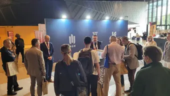 Group of people standing near promotional stand.