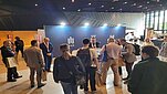 Group of people standing near promotional stand.
